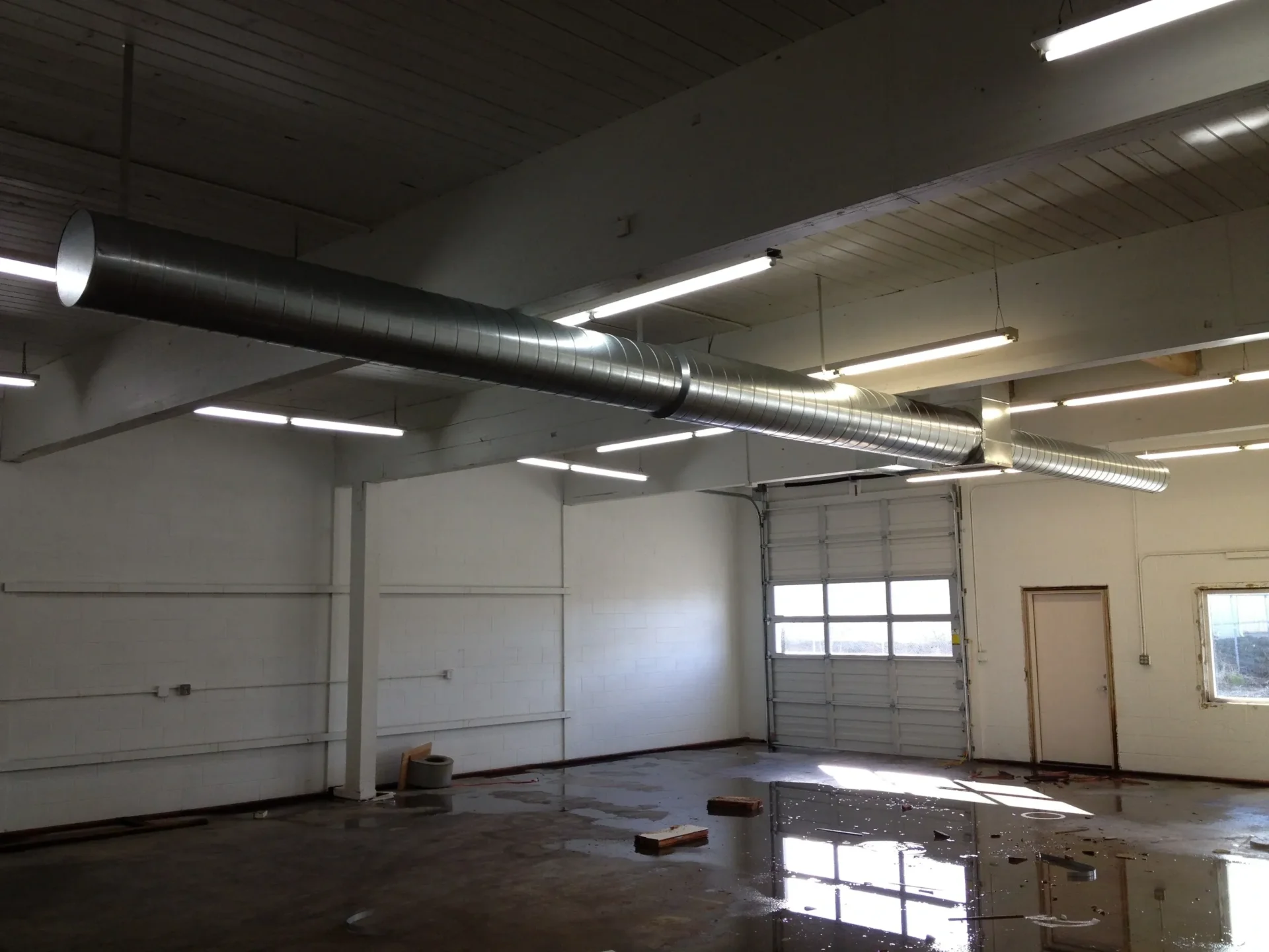 Empty warehouse interior with overhead ductwork.